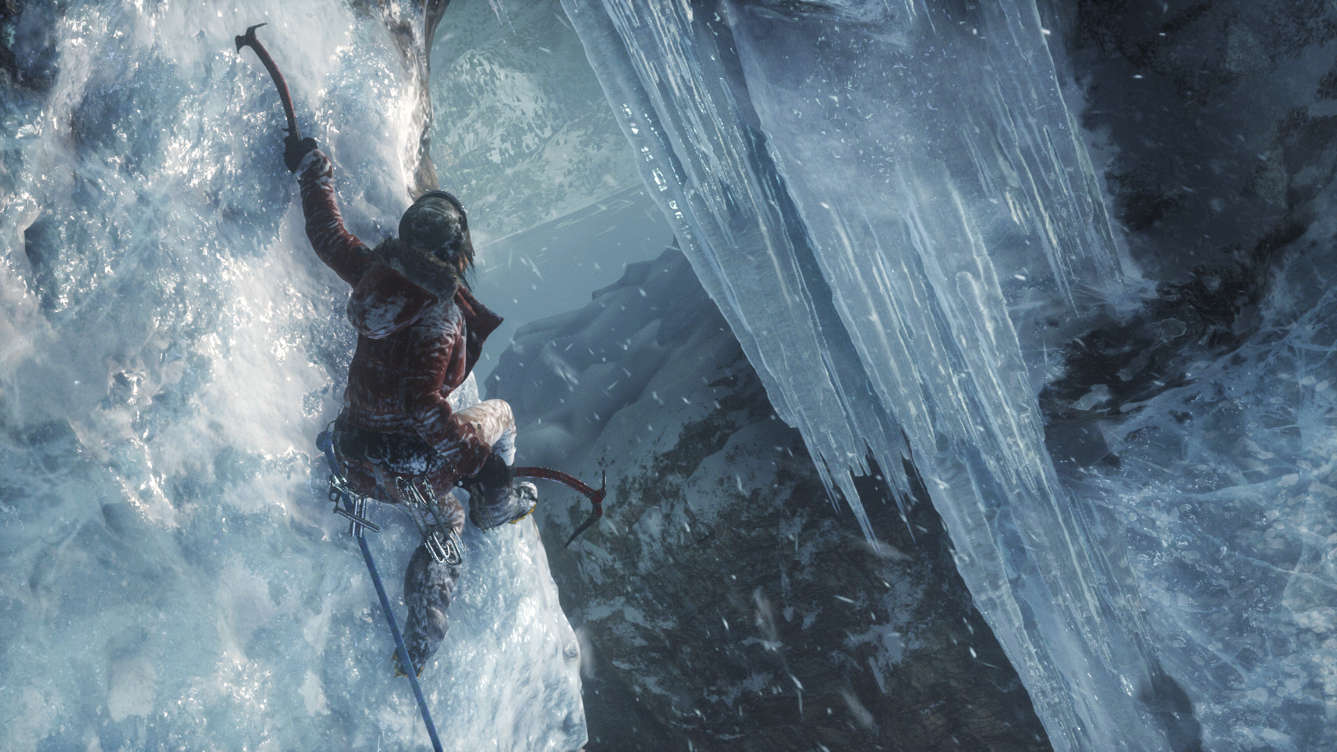 Lara clings to an ice wall with her red pickaxe, preparing to make a big leap.
